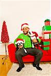 African man and dogs wearing Santa Claus hats