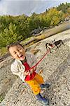 Asian boy holding dogs on leash