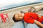 Asian boy lying on mother’s legs