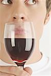 Young male adult smelling a glass of red wine