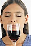 Female young adult smelling a glass of red wine