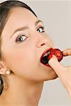 Femelle jeune adulte mange une fraise