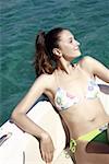 Female young adult on boat sunbathing