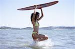 Weibliche junger Erwachsener mit Surfboard im Wasser