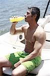 Männlichen Erwachsenen auf Boot Saft trinken
