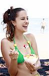 Weibliche junger Erwachsener Essen Joghurt und Obst am Strand