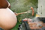 Femme enceinte de cuisson sur le barbecue