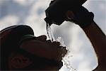 Silhouetted of a cyclist drinking water,  side view