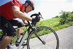 Vue latérale d'un homme cyclisme sur route