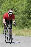 Front view of a man cycling on road