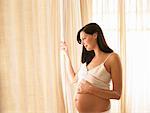 Pregnant woman looking through window