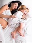 Pregnant mother and daughter laughing