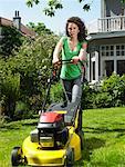 Woman mowing lawn in the sun