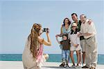 Mère prenant vidéo de famille au bord de mer