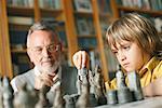 Young boy playing chess with grandfather