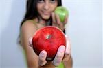 Young woman holding one red and one green apple