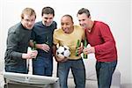 Four men with bottles of beer and football in front of TV