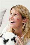 Jeune femme avec des couleurs allemandes sur son visage holding football