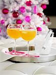 Orange Getränke mit Eiswürfeln, Weihnachtsbaum im Hintergrund