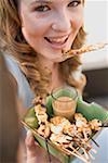 Femme manger grillée satay avec trempette aux arachides
