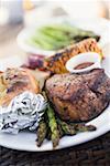 Grilled beef steak, asparagus, baked potato, corn on the cob