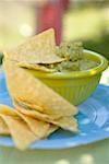 Guacamole mit Tortilla-chips in grüner Schale