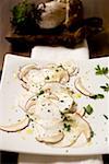 Cep carpaccio on chopping board in front of fresh cep