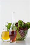 Oil and vinegar in carafes in front of salad bowl