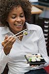 Woman eating sushi in office