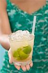 Woman holding glass of Caipirinha