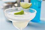 Margarita with lime wedges in a glass with a salted rim