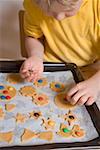 Enfant décorer des biscuits aux grains de chocolat colorés