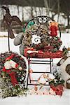 Christmas decorations on garden chair in snow