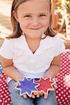 Small girl holding two star cookies (4th of July, USA)