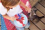 Small girl with partly-eaten cookie and cat (USA)