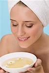 Woman with her hair wrapped in a towel, smelling herb tea