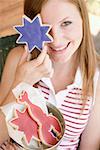 Woman holding a star cookie in front of her eye (4th of July, USA)