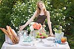 Woman presenting table laid in garden