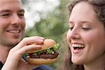 Mann mit Frau einen Bissen von hamburger