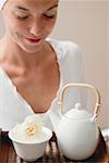 Femme tenant un plateau avec thé et blanc fleur