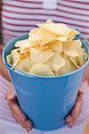 Woman holding crisps in blue bucket