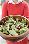 Frau hält große Schüssel Salat Blätter mit Muttern