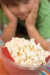 Popcorn in plastic bowl, child in background