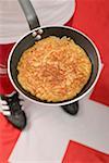 Footballer on Swiss flag holding frying pan with rösti