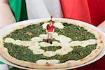 Football fan holding spinach and mozzarella pizza (Italy)