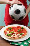 Tomato & mozzarella pizza, female footballer in background