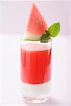 Watermelon drink with wedge of watermelon and mint leaves