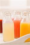 Divers jus de fruits différents en petites bouteilles sur plateau
