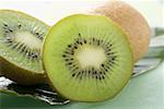 Deux moitiés d'un fruit kiwi devant toute kiwis