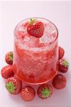 Fruity strawberry drink, surrounded by fresh strawberries